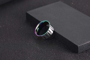 Macro detail of men's titanium ring with silver outer grooves and iridescent inner band