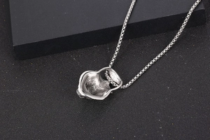 Detailed back view of a hollow skull pendant in silver titanium steel with a round box chain