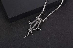 Detailed view of vintage titanium steel snake scale pendant on wheat chain necklace