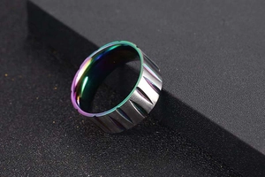Detail of wide brushed steel ring with vertical grooves and iridescent rainbow inner finish
