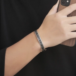 Silver Viking runes open cuff bracelet for men on a black knit fabric background
