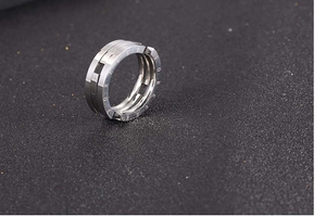 Macro shot of silver titanium ring with Forever Love engraving and mechanical tiered structure