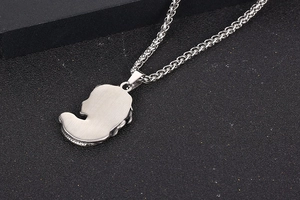 Vue macro du pendentif Méduse en acier titane avec texture brossée et chaîne en épi