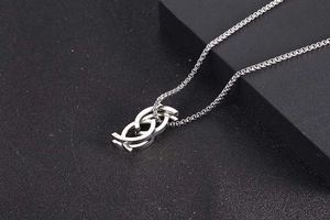 Macro shot of silver geometric interlocking pendant showing modern metallic luster