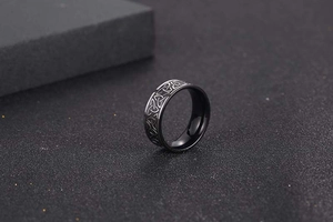 Macro view of black Viking ring featuring silver Celtic Trinity Knot relief patterns