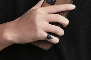 Detailed view of a vintage silver rooster ring with intricate feather textures on a finger