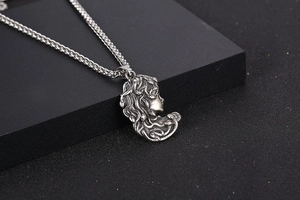 Vue macro du pendentif relief Méduse en argent vintage avec détail de chaîne dragon
