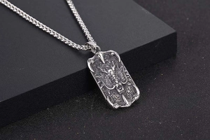 Detailed macro view of silver titanium dragon relief pendant on rectangular tag necklace