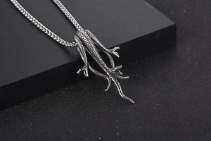 Macro detail of gothic titanium steel snake pendant with intricate scale textures and braided chain