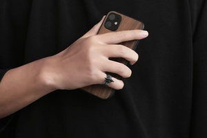 Macro shot of vintage rooster ring showing dark oxidized metal and rock-like textures