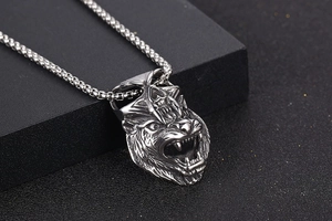 Macro shot of a vintage silver wolf and skull pendant with detailed gothic engraving