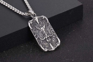 Close-up of a silver titanium steel dragon pendant necklace with intricate relief carving