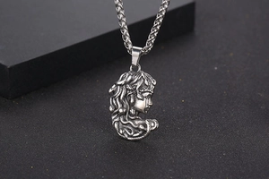 Gros plan du pendentif Méduse en argent antique avec texture de chaîne épi détaillée