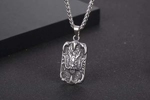 Detailed view of titanium steel dragon pendant with intricate relief and wheat chain
