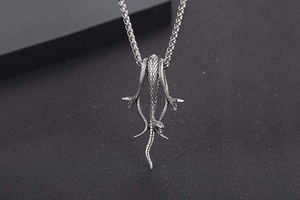 Detailed view of ancient silver snake pendant necklace with intricate scale textures