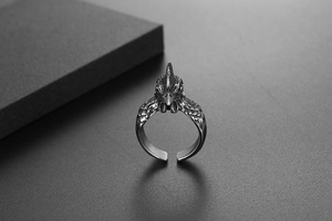 Macro detail of retro rooster ring featuring intricate feather texture and oxidized finish
