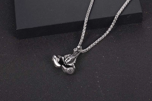 Detailed close-up of retro silver scorpion pendant with intricate textures on wheat chain