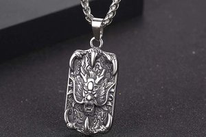 Macro shot of silver titanium steel dragon head pendant with detailed claw edges and chain