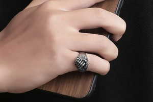 Détail de la bague poignée de main vintage en acier oxydé sur un doigt