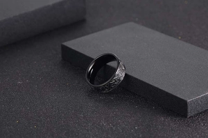 Macro shot of Nordic Viking Celtic knot pattern engraved on black matte steel men's ring