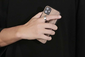 Close-up of minimalist silver titanium steel ring with parallel grooves on model's finger