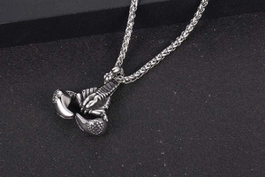 Macro shot of silver scorpion pendant with intricate segments on a dark textured base