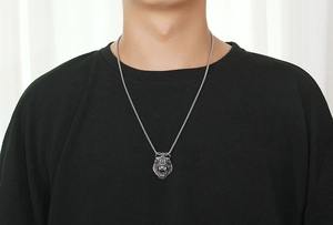 Macro detail of retro tiger head pendant and box chain on stainless steel necklace