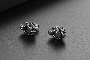 Macro detail of gothic titanium steel stud earrings with black zircon and claw setting
