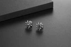 Macro shot of gothic sunburst star stud earrings in vintage black stainless steel