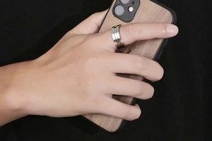Irregular silver titanium steel ring shown on finger in a creative hand-held phone scene