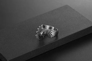 Detailed close-up of a vintage rooster ring with realistic feather textures in black metal