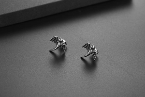 Détails macro de boucles d'oreilles dragon vintage en argent au style gothique