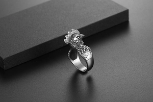 Detailed close-up showing the intricate feather textures of the vintage rooster ring