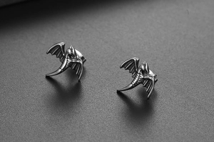 Gros plan détaillé des boucles d'oreilles en titane rétro en forme d'ailes de dragon