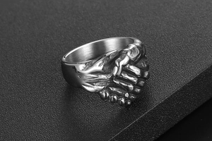 Macro de la bague poignée de main vintage montrant les détails des doigts et le métal texturé