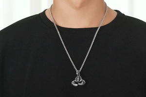 Detail shot of vintage silver scorpion pendant on a heavy braided steel chain necklace