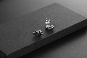 Macro view of gothic titanium steel ear studs with black zircon in eagle claw setting
