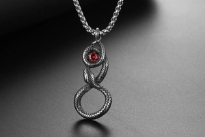 Détail macro du pendentif serpent en acier inoxydable avec pierre rouge et écailles