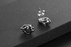 Macro shot of gothic titanium steel stud earrings with black stones and butterfly clasps