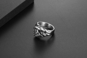 Détail d'une bague mains serrées vintage argentée avec gravure métallique texturée