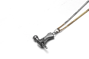 Détail macro de la chaîne en acier titane bicolore et du pendentif microphone réaliste