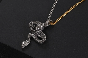 Detail of vintage titanium steel dragon pendant featuring intricate metal scales and mixed-tone chain