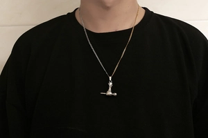 Détail d'un collier bicolore en acier inoxydable avec pendentif marteau industriel