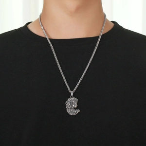 Collier avec pendentif Méduse vintage en argent et chaîne blé sur chemise noire