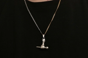 Détail du pendentif microphone en acier titane sur une chaîne bicolore or et argent