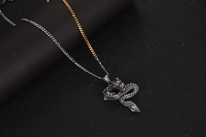 Macro detail of retro dragon pendant with textured scales and gold-silver chain links