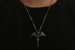 Detail of gothic dragon wing sword pendant with unique gold and silver split chain