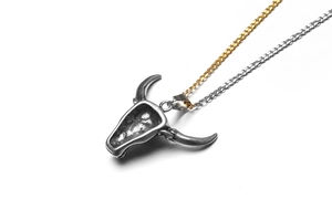 Détail du pendentif tête de buffle vintage en acier avec chaînes dorées et argentées