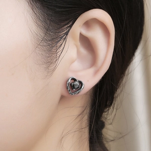 Nahaufnahme von Vintage Herz-Ohrstecker mit schwarzem Zirkonia am Ohrläppchen