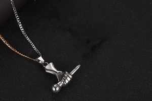 Détail du pendentif main en acier titane tenant une sphère sur chaîne bicolore